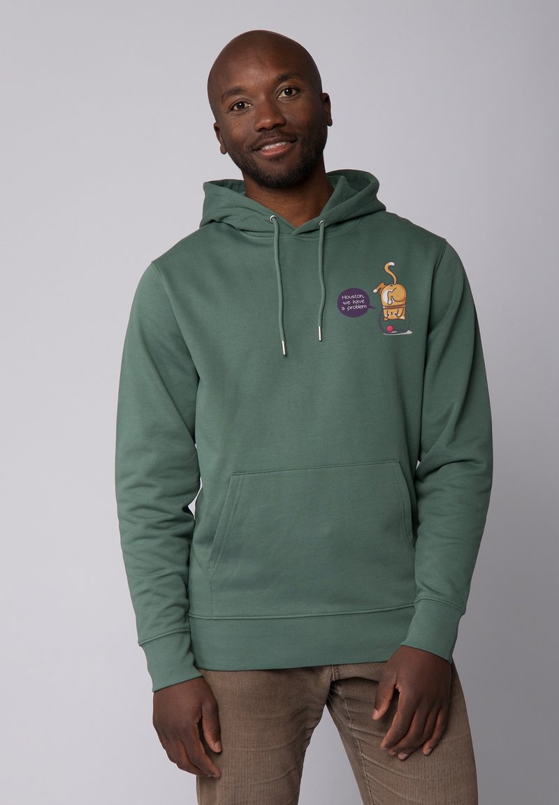 Groene hoodie gemaakt van zacht materiaal, met een voorzak, capuchon met trekkoord en een speelse graphic van een hond met een paarse label.