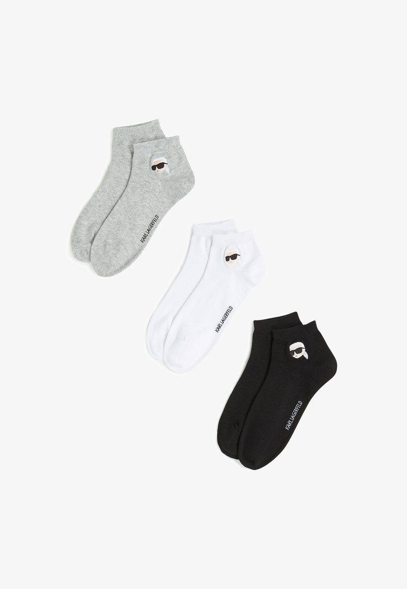 Three pairs of ankle socks in gray, white, and black. Each features a logo design and is crafted from soft, flexible material.