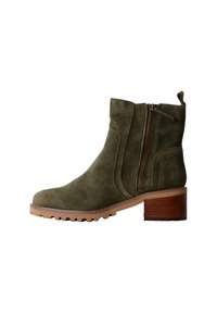 Stivale alla caviglia in suede verde oliva con zip laterale, tacco a blocco e suola texturizzata. Presenta dettagli cuciti e una linguetta sul retro.