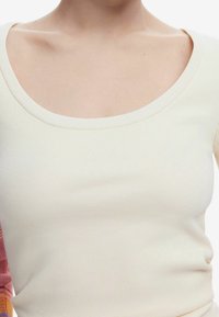 Top a coste color crema con scollo ampio, design aderente e maniche corte a fantasia scozzese nei colori rosa e arancione.