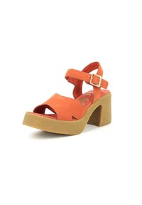 Sandali platform in suede arancione con punta aperta, cinturino alla caviglia e tacco quadrato. Suola in gomma texturizzata, piccolo dettaglio con fibbia sul cinturino.