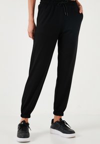 REGULAR FIT. - Spodnji deli trenirk - black