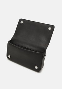 Musta nahkainen käsilaukku, jonka läppä on auki ja jossa on hopeanväriset metalliosat. Laukussa on sileä pinta ja kaksi magneettista napsautuslukkoa sisäpuolella.