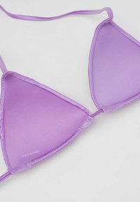 Haut de bikini triangulaire violet avec fines bretelles, texture lisse et logo discret "TEZENIS" en bas à gauche du bonnet gauche.