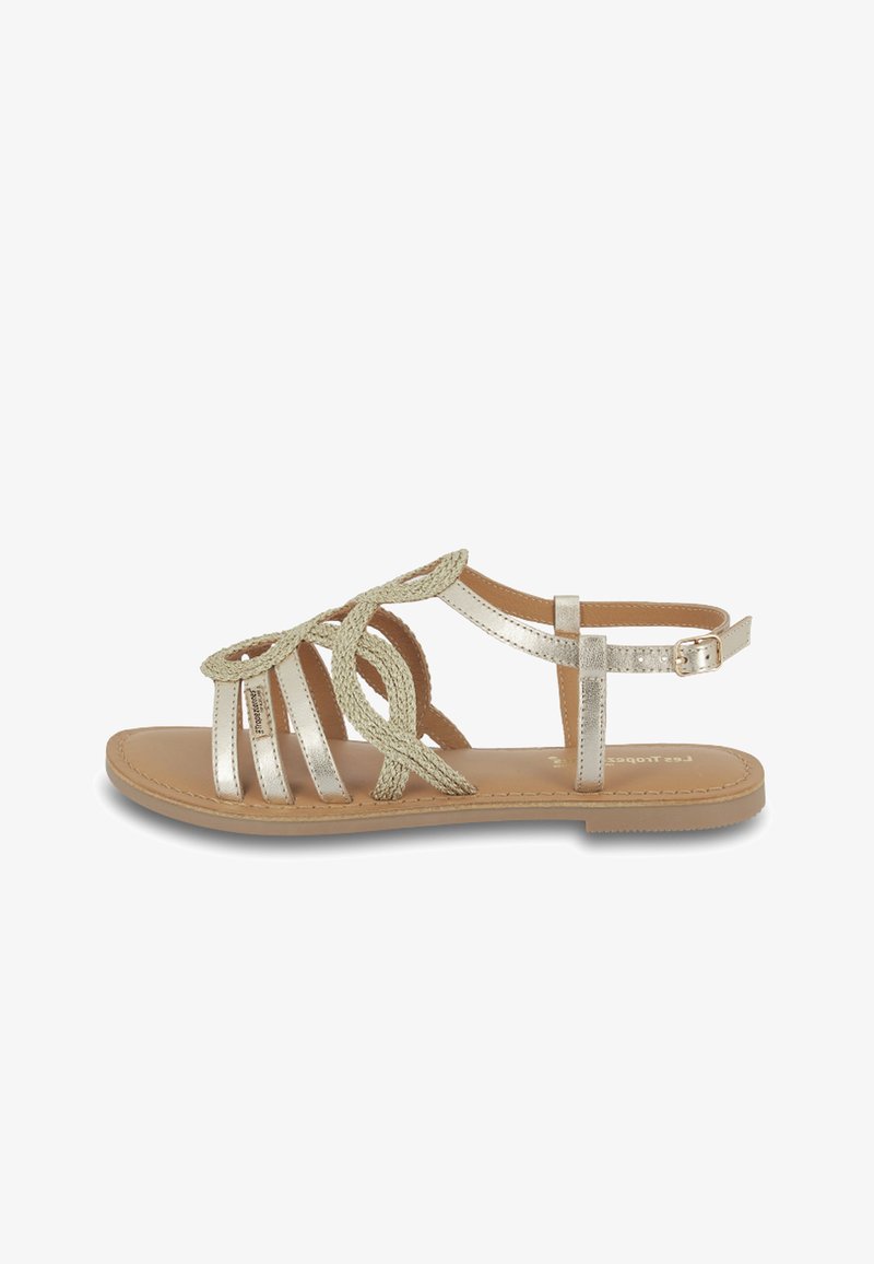 Gouden metallic sandalen met gevlochten banden, platte tan kleurige zool, verstelbare enkelgesp en open teen ontwerp. Zachte textuur en casual stijl.