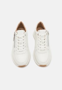 Weiße Leder-Sneaker mit Schnürung vorne, seitlichem Reißverschluss, runder Zehenform und beigem Innenfutter. Gummisohle mit subtiler Struktur und Form.