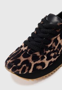 Baskets en imprimé léopard avec une tige en textile noir, des lacets texturés et une semelle en caoutchouc à bords dentelés pour plus d'adhérence et de style.