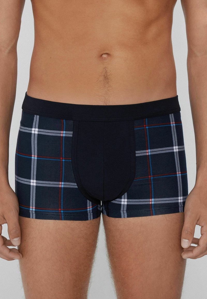 Boxershorts mit einem navyblauen und karierten Design in Rot und Weiß. Hergestellt aus weichem Stoff mit einem bequemen Bund und figurbetontem Schnitt.