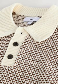 Knitted sweater with a cream, ribbed collar and brown geometric pattern. Features three dark buttons at the neckline and a label.