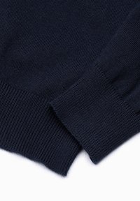 Mörkblå stickad tröja med ribbade cuffs och nederkant, med en slät textur och en figurnära design.