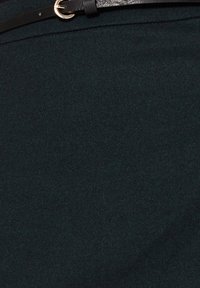 Schwarzer Leder Gürtel mit einer goldfarbenen Metallschnalle, kombiniert mit einem dunkelgrünen Stoff, der eine strukturierte Oberfläche und ein dezentes diagonales Muster aufweist.