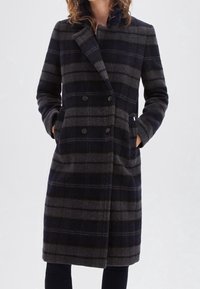 Woolen double-breasted coat featuring a navy and grey plaid pattern, notched collar, side pockets, and long sleeves.