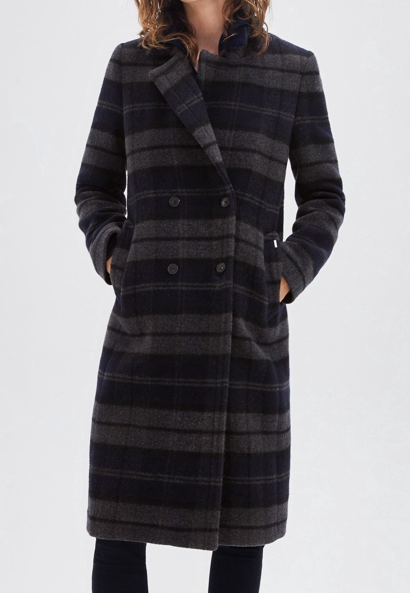 Woolen double-breasted coat featuring a navy and grey plaid pattern, notched collar, side pockets, and long sleeves.