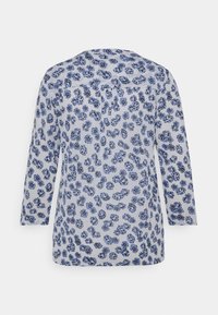 Blaue Bluse mit drei Viertelärmeln, die einen hellblauen Hintergrund und eine Vielzahl von blauen Blumenmustern aufweist. Hergestellt aus weichem Stoff.
