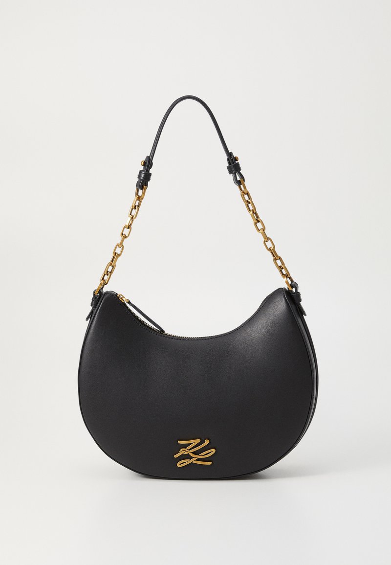 Schwarze Leder-Schultertasche mit einer geschwungenen Form, goldenen Hardware-Akzenten und einem Kettenriemen. Mit einem Reißverschlussverschluss und einem Markenlogo-Detail.
