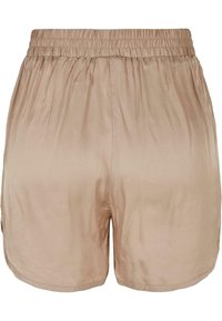 Shorts en satin beige avec une ceinture élastique ; texture lisse et finition légèrement brillante ; ourlet incurvé aux jambes.