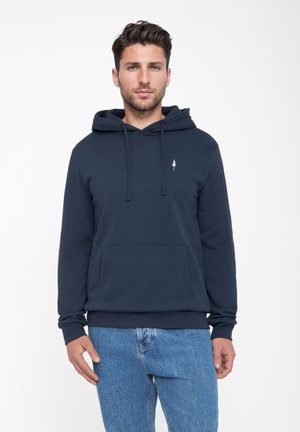 Marineblauwe hoodie van zacht materiaal, met een voorzak, verstelbare koordjes en een klein boomembleem op de borst.