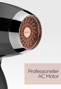 Primo piano di un asciugacapelli nero che mostra la sua presa d'aria posteriore color rame con la scritta "BaByliss" e il testo "Motore AC professionale".