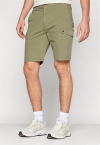 Pantaloni cargo verdi oliva con taglio dritto, tasche laterali e dettagli a bottone a pressione. Realizzati in tessuto leggero, adatti per il clima caldo.