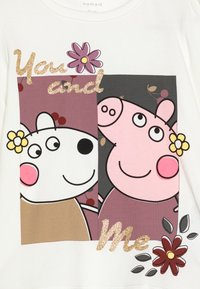 Weißes Langarmshirt mit Cartoonfiguren. Der Text "Du und Ich" in Glitzer ist von bunten Blumen und einem floralen Muster umgeben.