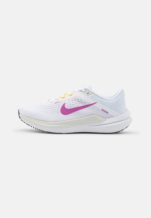 Scarpe da corsa Nike con una tomaia in rete bianca, swoosh viola, accenti gialli e viola, e suola in gomma nera texturizzata.
