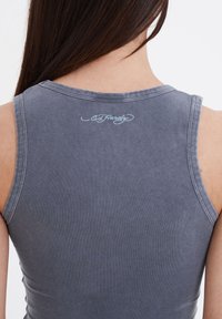 Gray tank top made of soft cotton. Features a round neckline and sleeveless design. Ed Hardy logo embroidered on the back.