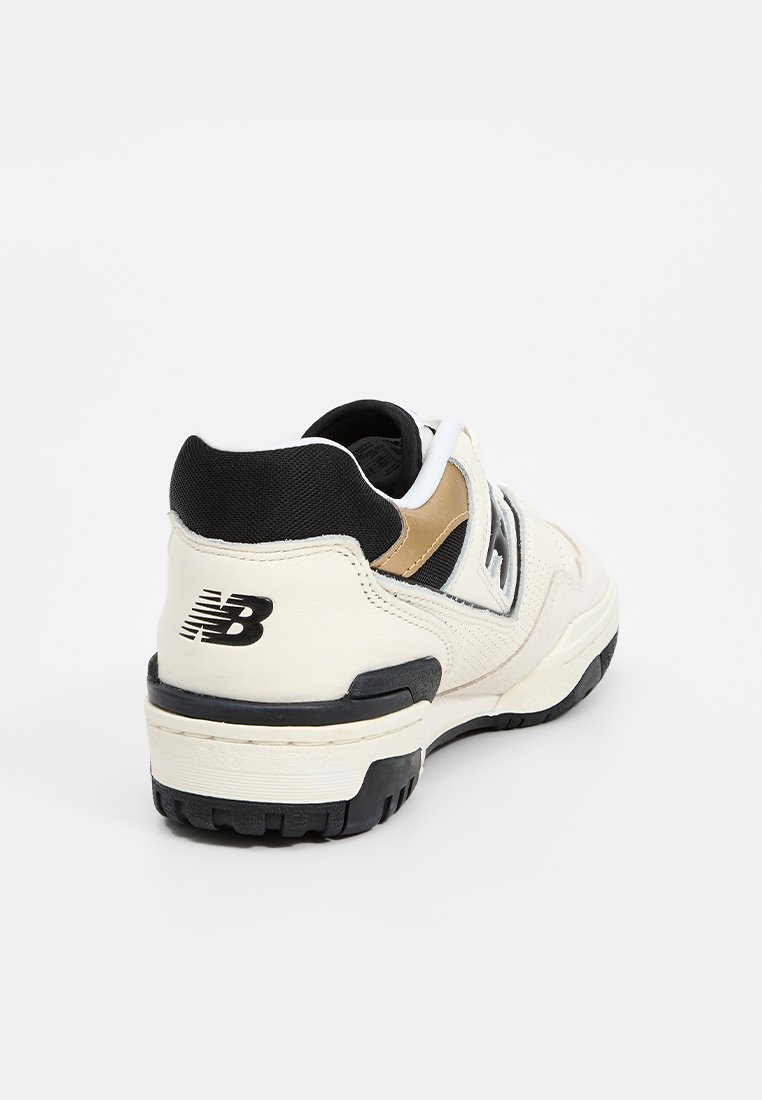 Weißer und schwarzer Sportschuh mit einer strukturierten Oberseite, Wildleder- und Lederpaneelen, einem gepolsterten Kragen und einer Gummisohle mit einem Profilmuster.