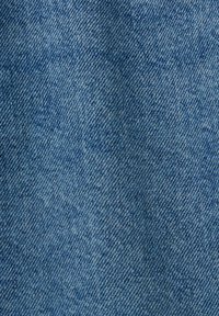 Tejido de mezclilla en azul claro, que muestra un clásico tejido de sarga con una superficie texturizada y sutiles variaciones en la intensidad del color.