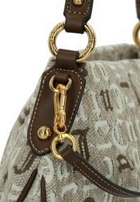 Bolso de tela beige con letras en relieve, correas de cuero marrón y herrajes metálicos en tono dorado con detalle de cierre tipo langosta.