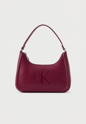Borsa in pelle bordeaux con logo "cK" impresso e singolo manico corto, dotata di chiusura con zip e accessori in metallo argento.