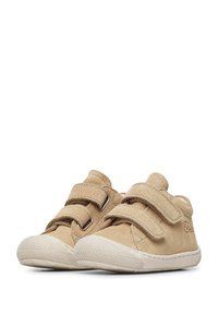 Beige velurové boty pro batolata se dvěma nastavitelnými suchými zipy, kulatou špičkou a bílou gumovou podrážkou se strukturovaným vzorem.