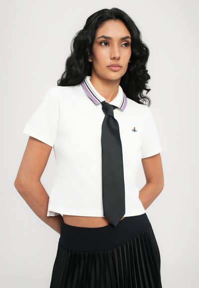 Hvid polo skjorte med et sort slips, der har en krave i lilla og sort stribet design. Skjorten har en tætsiddende pasform og korte ærmer.