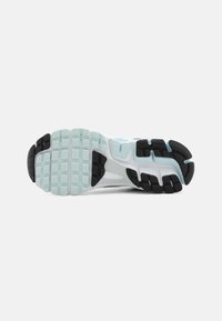 Gray and light blue sneaker sole with a textured black rubber grip, featuring a pattern of squares and rectangular lugs for traction.