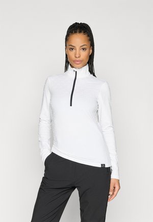 Vit långärmad zip-up tröja med hög krage, texturerad design och svart dragkedja. Matchad med svarta byxor.