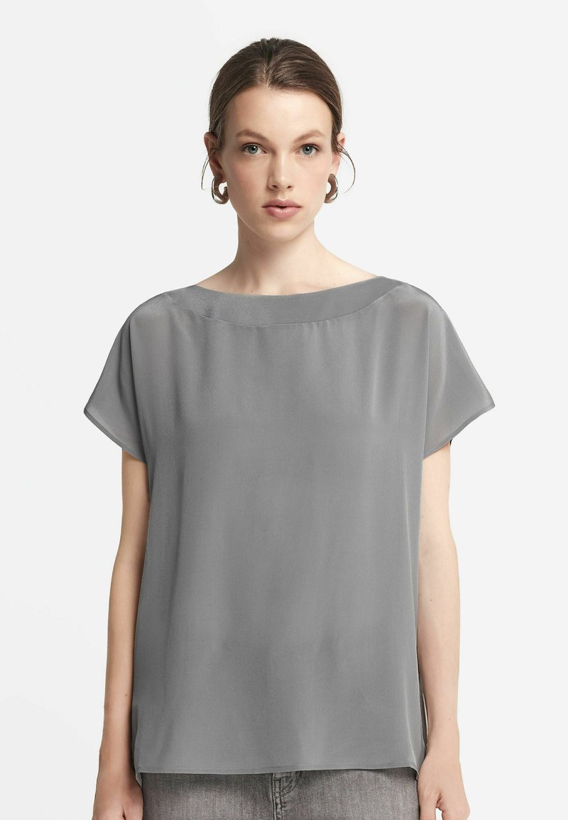 Grå kortärmad blus med vid halsringning och lös passform. Slät, lättviktig tyg med en subtil glans. Minimalistisk design utan mönster.