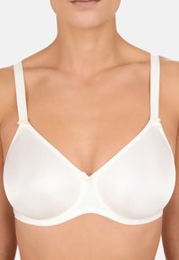 Sottile reggiseno color crema con tessuto liscio, supporto con ferretto e spalline regolabili. Presenta piccoli fiocchi decorativi alla base delle spalline.