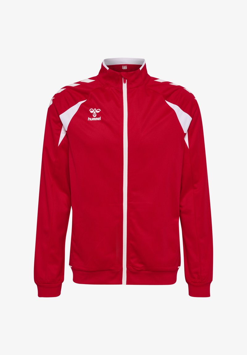 Veste de sport rouge avec fermeture éclair blanche, bandes blanches en forme de chevron sur les épaules, panneaux latéraux blancs et logo Hummel sur le côté gauche de la poitrine.