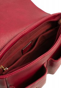 Interno di una borsa rossa in pelle con scomparti con zip, finitura testurizzata e rivestimento morbido. Presenta molteplici tasche per l'organizzazione.