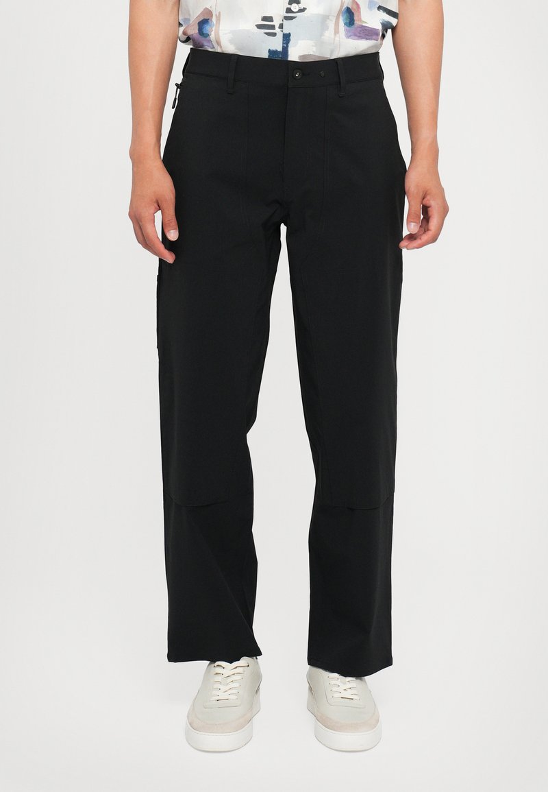 Pantalones negros de diseño recto, con bolsillos con cremallera, costuras visibles y una tela suave y ligera.