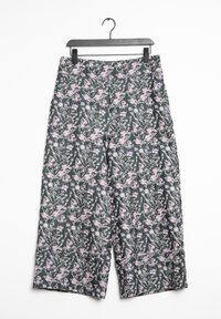 Bloemen wijde broek in donkergroene stof met een roze en witte bloemmotief, met een hoge tailleband en hangend aan een zwarte haak.