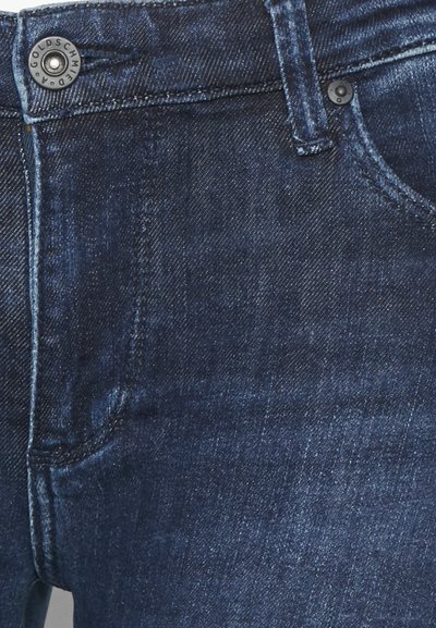 Jeans de ganga azul escuro com uma textura suave, design de cinco bolsos, fecho com botão de metal e detalhes de costura subtil.