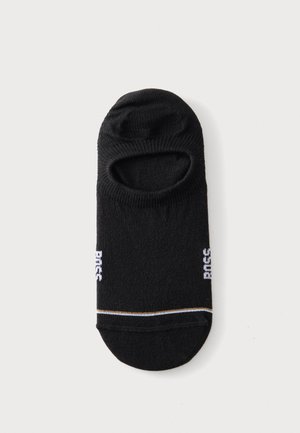 Chaussette invisible noire avec une bande blanche et dorée près des orteils et un texte blanc sur les côtés, présentée à plat sur fond blanc.