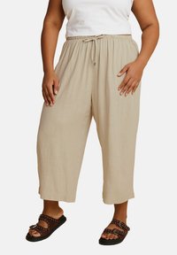 Beige, lichte, cropped broeken met een elastische tailleband en verstelbaar trekkoord. Glad oppervlak, wijde pootontwerp en subtiele glans.