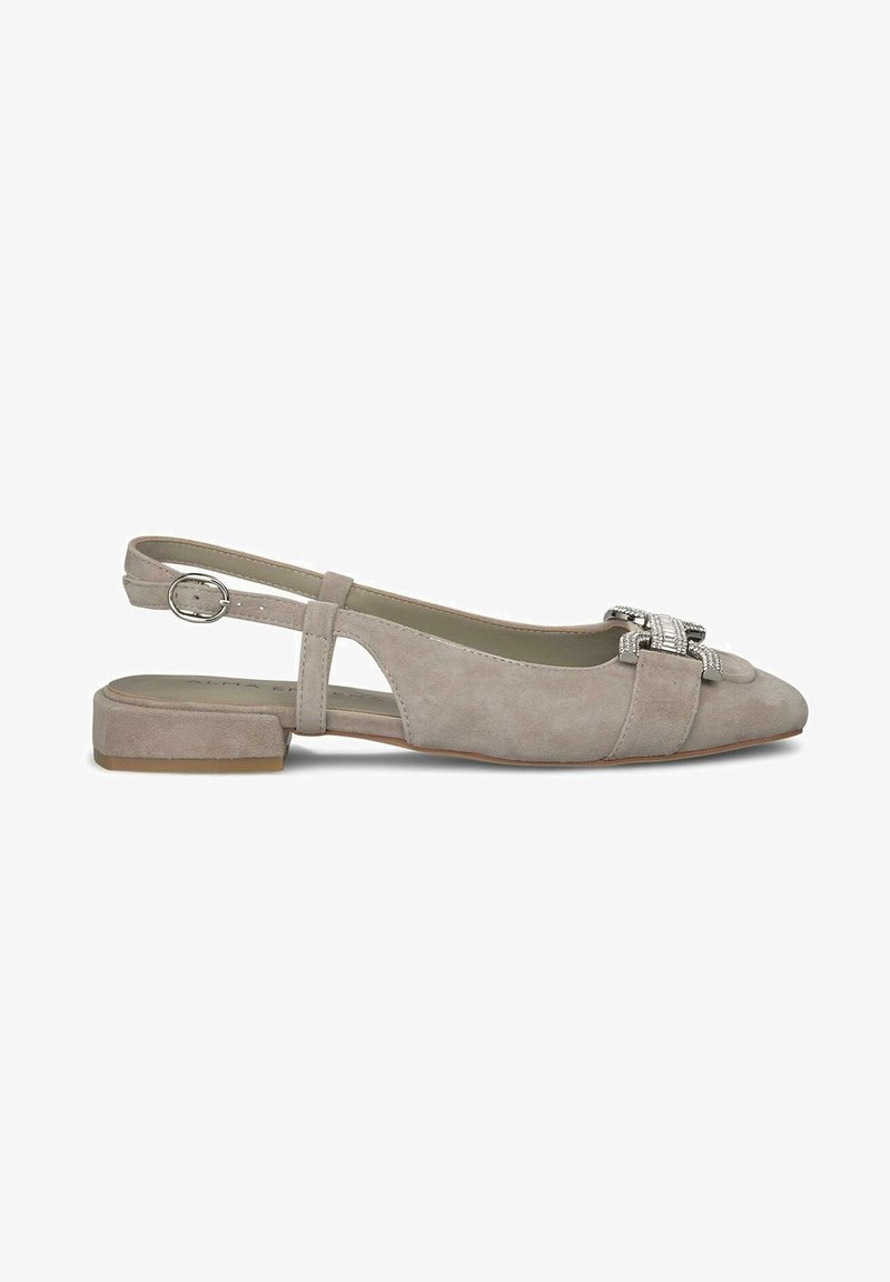Ballerine slingback in suede beige chiaro con punta affusolata, fibbia decorativa argentata e tacco basso a blocco. Le aperture laterali aggiungono dettaglio.