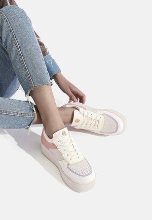 Sneaker con una toma crema e accenti rosa e viola pastello, suola testurizzata e zona delle dita perforata per la traspirazione.