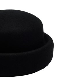 Czarny filcowy kapelusz wełniany z zaokrągloną koroną i szerokim, płaskim rondem. Gładka tekstura, minimalistyczny design, bez dodatkowych wzorów czy akcentów.