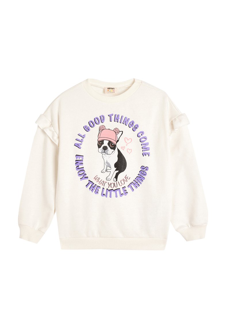 Sudadera blanca con acentos de volantes en las mangas, que presenta un gráfico de un perro con un sombrero rosa y texto morado que dice "Todo lo bueno llega."