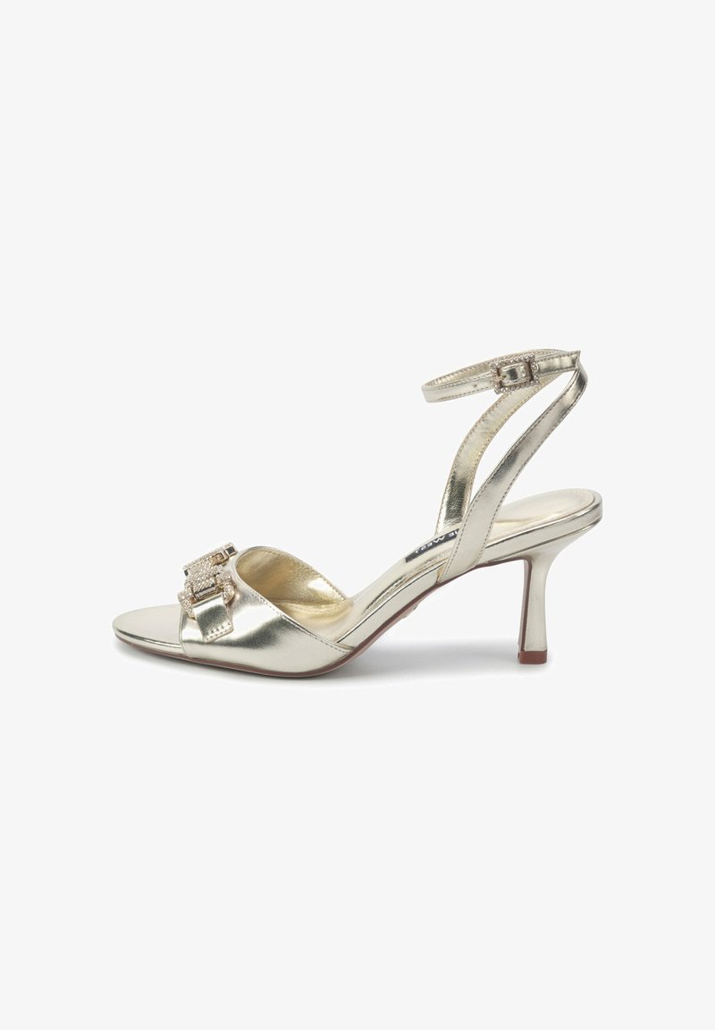 Sandale aurii metalice cu toc subțire și curea la gleznă, vârful deschis și detaliu decorativ cu cataramă. Au un toc subțire, tip stiletto, și o textură netedă.