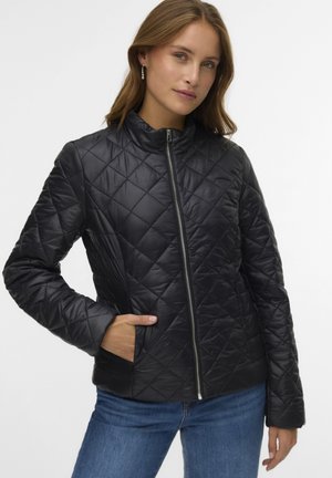 Giacca nera trapuntata con collo alto, cerniera frontale e tasche laterali. Realizzata in materiale liscio e riflettente con motivi a diamante.