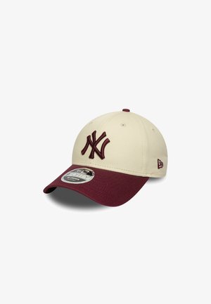 Casquette de baseball avec un dessus crème, une visière bordeaux et un logo "NY" brodé en bordeaux assorti. Elle possède une visière incurvée et une sangle réglable.